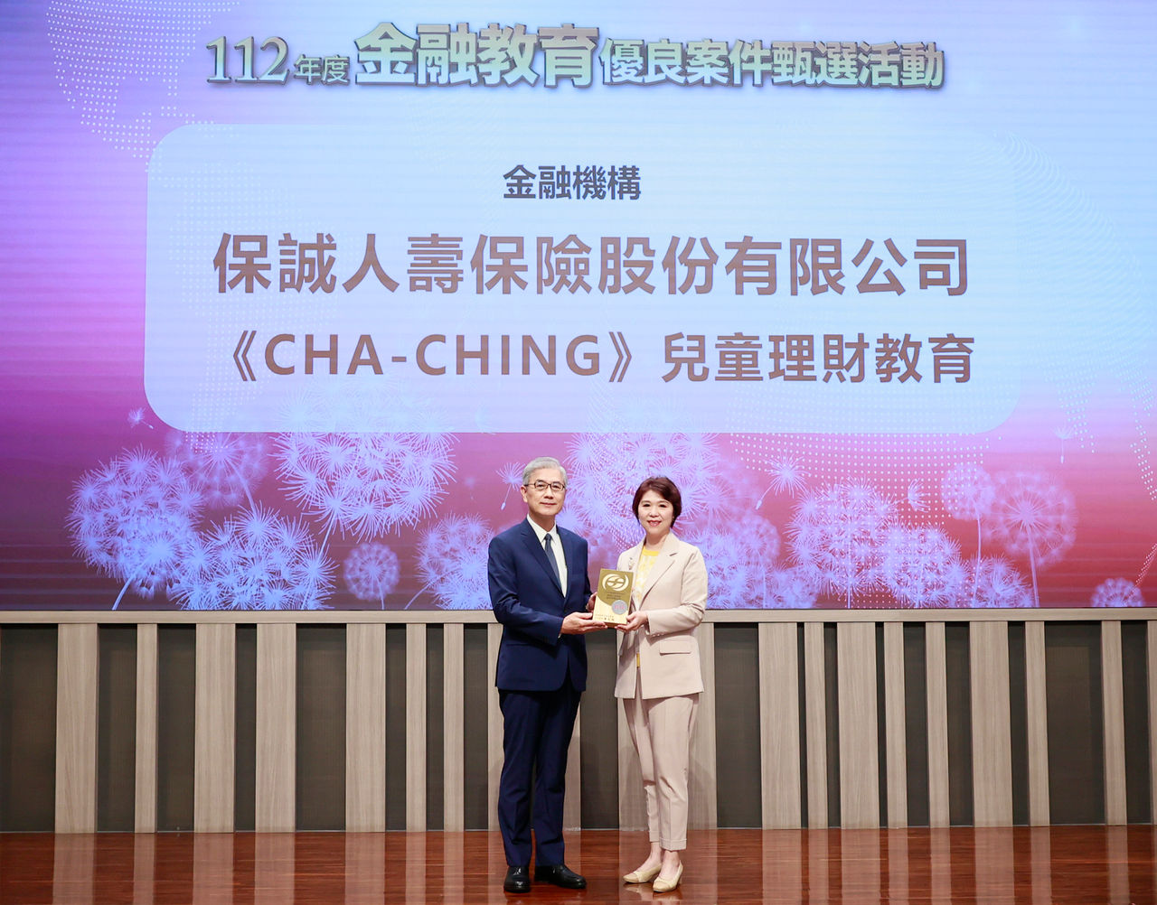 保誠人壽榮獲112年度金融教育優良案件，總經理王慰慈(右)代表接受金管會主委黃天牧表揚